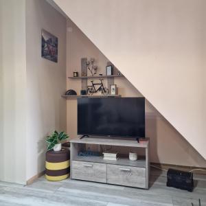 a living room with a flat screen tv sitting under a staircase at Skver apartman in Paraćin