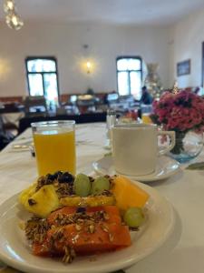 a plate of food on a table with a glass of orange juice at Hotel Posada San Rafael in Pátzcuaro