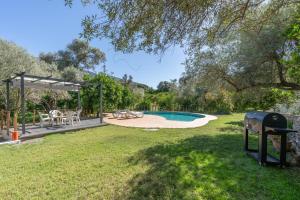 a backyard with a pool and a table and chairs at Cortijo Corral del Gallo in Órgiva