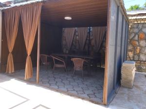 a covered patio with a table and chairs at Uyut house Osh in Osh +6 photos