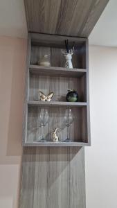 a shelf with wine glasses and other items on it at Skver apartman in Paraćin