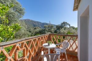 a wooden balcony with a table and chairs on it at Cortijo Corral del Gallo in Órgiva