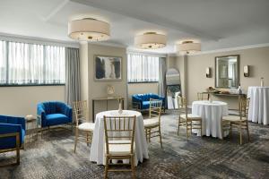 a dining room with tables and chairs and windows at Falls Church Marriott Fairview Park in Falls Church