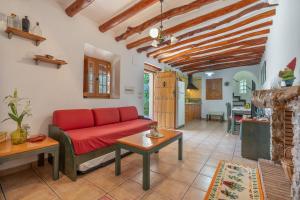 a living room with a red couch and a table at Cortijo Corral del Gallo in Órgiva