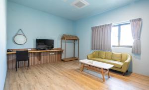 a living room with a couch and a table at 戀海輕旅Ocean Pride Hostel in Xiaoliuqiu