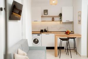 a kitchen with a table and a washing machine at White Nest Rooms in Potos