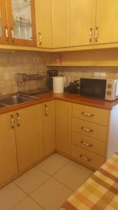 a kitchen with a sink and a microwave at Nineta's House Sea View near the Airport in Artemida