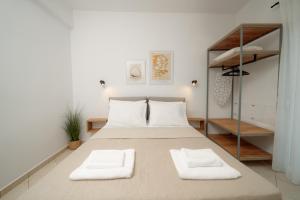 a bedroom with a large bed with two white towels at White Nest Rooms in Potos