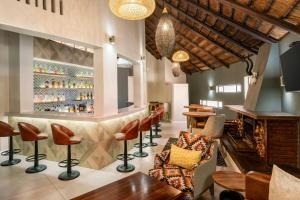 a bar at a restaurant with chairs and tables at Protea Hotel by Marriott Oudtshoorn Riempie Estate in Oudtshoorn