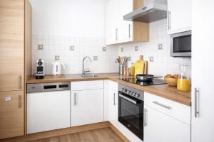 a kitchen with white cabinets and a sink at APSTAY central station I Self Check-in I Parking option in Graz