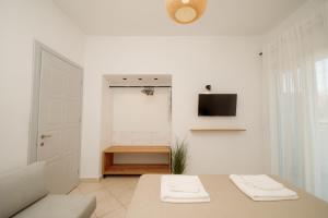 a white room with a table with two folded towels at White Nest Rooms in Potos