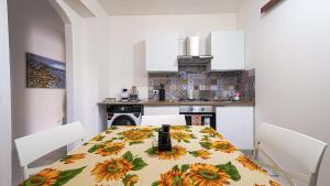 a kitchen with a table with a sunflower table cloth at Villa Xenia in Pizzo +11 photos