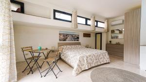a bedroom with a bed and a table and two windows at Villa Xenia in Pizzo