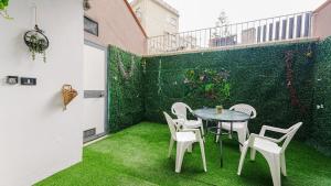 a patio with a table and chairs and a green wall at Villa Xenia in Pizzo