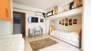 a bedroom with two beds and a desk and a tv at Villa Xenia in Pizzo