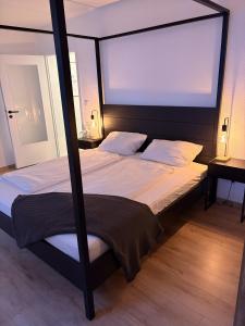 a bedroom with a four poster bed with a large window at FeWo Grote in Warburg