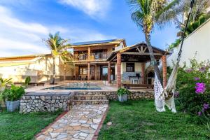 a house with a swimming pool and a palm tree at Ocean View Beira-Mar no Centro de Canoa in Canoa Quebrada