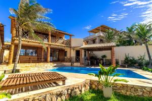 a villa with a swimming pool and a house at Ocean View Beira-Mar no Centro de Canoa in Canoa Quebrada