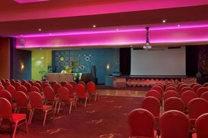 an empty room with red chairs and a stage at Delta Hotels by Marriott Marrakech Eden Andalou in Marrakesh +138 photos