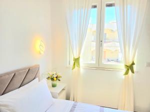 a bedroom with a bed and a window with curtains at Home Julia in Massa Lubrense