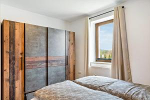 a bedroom with a bed and a window at Ferienwohnung Heimelig im Bayerwald in Haidmühle