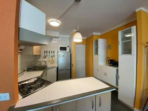 a kitchen with yellow walls and white cabinets at DEPARTAMENTOS TERMAS DE CHILLAN in Nevados de Chillan