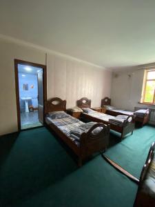 a room with three beds and a room with a doorway at Hostel Inn in Andijan