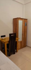 a wooden desk with a chair next to a cabinet at RS Green Barathi in Kilinochchi