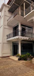 a large white building with a balcony and plants at RS Green Barathi in Kilinochchi