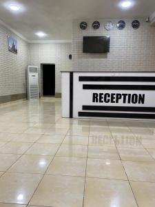 a reception room with a sign on a wall at Hostel Inn in Andijan