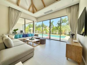 a living room with a couch and a table at Bali-Style 4 BR Private Pool Villa - Trichada in Phuket