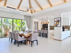 a dining room and living room with a table and chairs at Bali-Style 4 BR Private Pool Villa - Trichada in Phuket
