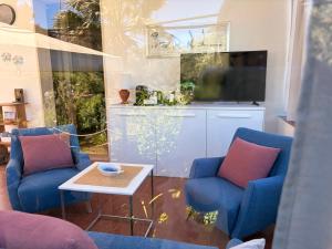 a living room with two blue chairs and a table at La Villetta in Lacona