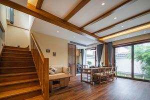 a living room with a staircase and a table at MOUNT WELL RESORT HOTEL in Lijiang