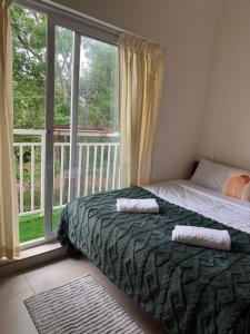 a bedroom with a bed and a large window at Little Retreats in Nedumbassery