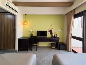 a bedroom with a desk and a computer in a room at SUNSHINE BEACH Resort in Mui Ne