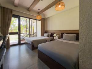 a hotel room with two beds and a window at SUNSHINE BEACH Resort in Mui Ne +47 photos
