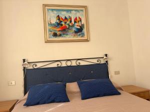 a bedroom with a bed with a painting of boats at La Villetta in Lacona