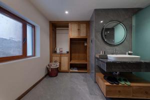 a bathroom with a sink and a mirror at MOUNT WELL RESORT HOTEL in Lijiang +109 photos