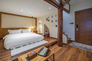 a bedroom with a large bed and a table with a keyboard at MOUNT WELL RESORT HOTEL in Lijiang