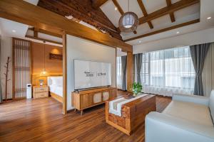 a living room with a large screen tv in a room at MOUNT WELL RESORT HOTEL in Lijiang
