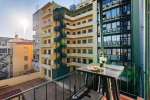 a balcony with a table and a building at Guest Inn 2 Boutique House in Lisbon +100 photos