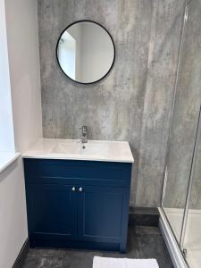 a bathroom with a blue sink and a mirror at Sycamore Stay in Spalding +18 photos