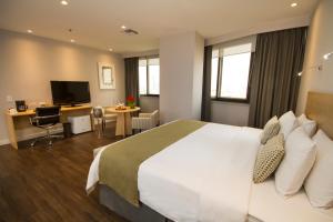 a hotel room with a large bed and a desk at Unipark by Oro Verde Hotels in Guayaquil