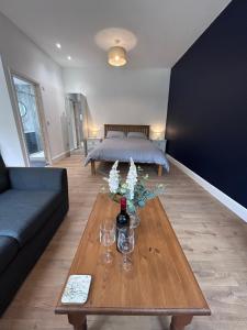 a living room with a couch and a table with wine glasses at Sycamore Stay in Spalding