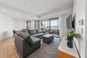 a living room with a couch and a table at Kove Apartment - B02 in Kiama +3 photos