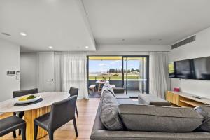 a living room with a couch and a table and chairs at Kove Apartment - B02 in Kiama