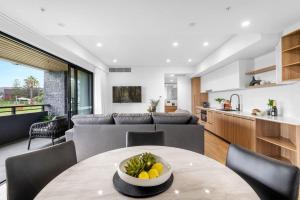 a kitchen and living room with a table and chairs at Kove Apartment - B02 in Kiama
