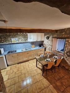 a kitchen with a table and chairs in a room at authentieke gite Mouton in Les Vignolats