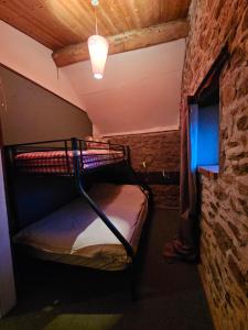a bunk bed in a room with a brick wall at authentieke gite Mouton in Les Vignolats +4 photos